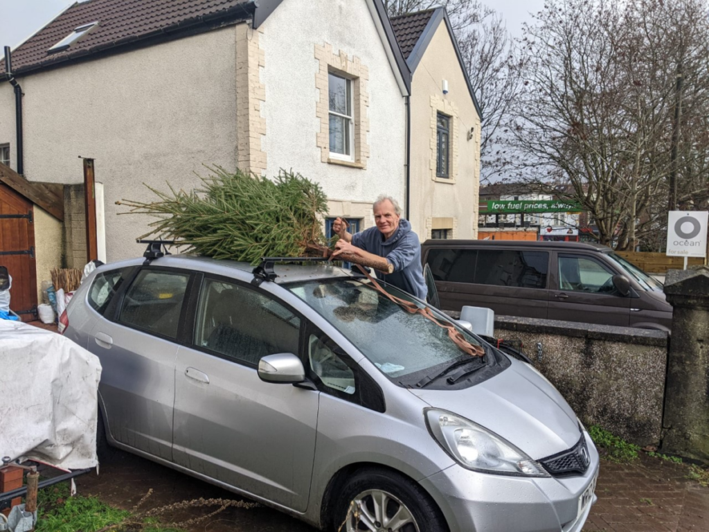 Our volunteer attaching the tree that he grew to the roof rack of his car