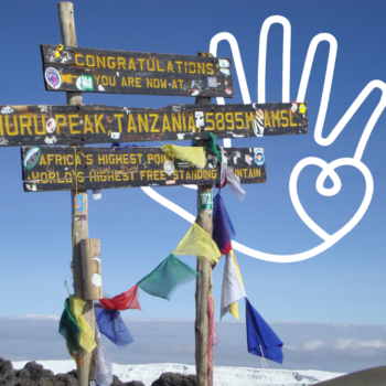 The highest point of Kilimanjaro, with sign and flags.
